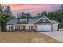 Charming home with stone accents, attached two car garage and beautiful sunset backdrop at 1025 Baylor Grv, Monroe, NC 28112