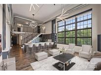 Open living room with modern kitchen and high ceilings at 715 N Graham St # 201, Charlotte, NC 28202