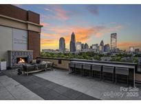 Relaxing rooftop terrace with city views, fireplace, and seating at 715 N Graham St # 201, Charlotte, NC 28202