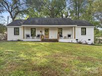 Charming white brick home featuring a covered front porch and well-manicured lawn at 3317 Sargeant Dr, Charlotte, NC 28217
