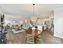 Bright living room featuring a decorative chandelier, modern furnishings, and dark, beautiful hardwood floors at 9126 Vecchio Dr, Indian Land, SC 29707