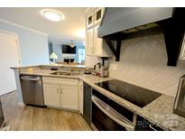 This kitchen features granite countertops, stainless steel appliances, and modern white cabinets at 18867 Vineyard Point Ln, Cornelius, NC 28031