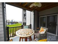 Enjoy outdoor relaxation on this charming patio with stylish wicker furniture and community views at 18867 Vineyard Point Ln, Cornelius, NC 28031