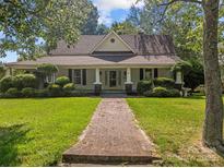 Charming home featuring a brick walkway, manicured lawn, and a welcoming front porch at 405 7Th St, Spencer, NC 28159