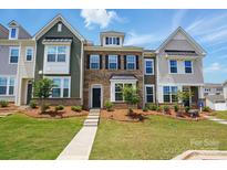 Charming townhome showcases a well-manicured lawn, varied siding, and a welcoming front entrance at 939 Cobbled Way, Fort Mill, SC 29715
