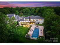Stunning aerial view of the property showcasing its luxurious pool and lush landscaping in a private setting at 2116 Woodhaven Rd, Charlotte, NC 28211