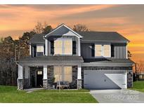 Two-story home with gray siding, stone accents, and a two-car garage at 2040 White Cypress Ct # Kh09, Charlotte, NC 28216