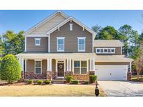 Charming two-story home with a covered porch, stone accents, and a well-manicured front yard at 16840 Rudence Ct, Charlotte, NC 28278