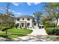 Stunning two-story home with white brick exterior, landscaping, and driveway at 1446 Queens W Rd, Charlotte, NC 28207