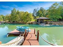 Scenic view of a private dock with kayaks on a calm lake, featuring a covered boat slip at 156 Marietta Rd, Mooresville, NC 28117