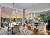 Bright, open living space with floor-to-ceiling windows and hardwood floors at 215 N Pine St # 3705, Charlotte, NC 28202