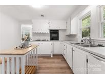 Bright kitchen with white cabinets, new flooring, and an island at 217 Burrage Ne Rd, Concord, NC 28025