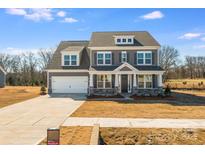 New construction with a gray color scheme, stone accents, and three-car garage at 5735 Allburn Pkwy, Concord, NC 28027