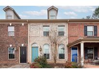 Brick front of charming townhome with teal and blue doors at 11770 Redbridge Blvd, Locust, NC 28097