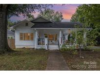 Charming white house with a porch and well-manicured lawn at 317 Kerr Nw St, Concord, NC 28025