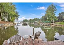 Inviting dock view with chairs and small table overlooking the serene lake and boat docks, perfect for lakeside relaxation at 470 Lakeview Shores Loop, Mooresville, NC 28117