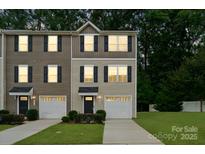 Charming two-story townhome with light siding, black shutters, well-kept lawn, and an attached one-car garage at 5008 Winding Jordan Ln, Charlotte, NC 28269