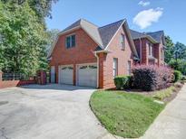 Attached two-car garage with a concrete driveway and manicured landscaping at 907 Weymouth Dr, Gastonia, NC 28056