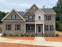 Beautiful two-story brick home with a covered front porch and manicured landscaping in a desirable neighborhood at 8605 Carly Ln, Mint Hill, NC 28227