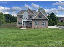 Beautiful two-story brick home with a manicured lawn and lake view at 9411 Stonebridge Way # 49, Mint Hill, NC 28227