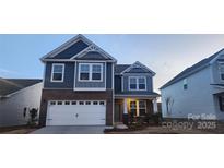 Beautiful two-story home boasts a mix of brick and siding, attached garage, and classic architectural details at 136 Ella Claire Dr, York, SC 29745
