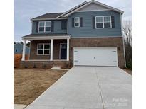 Charming two-story home showcasing a brick and siding facade, complemented by a well-manicured lawn and a spacious two-car garage at 107 Rustling Waters Dr, Mooresville, NC 28117