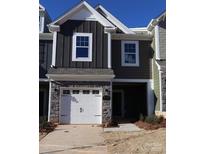 Modern two-story townhome with gray siding, stone accents, and a two-car garage at 4057 Lawnview Dr, Charlotte, NC 28269