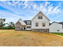 Inviting two-story home with stone accents, white siding, wood shutters, and manicured lawn at 2059 Parks Rd, Salisbury, NC 28147