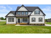Charming two-story home with a modern white exterior, black shutters, a well-manicured lawn, and covered front porch at 2025 Parks Rd, Salisbury, NC 28147