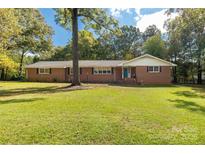 Brick ranch house with a spacious lawn and mature trees at 709 Plantation Rd, Lancaster, SC 29720