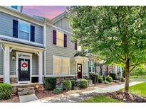 Modern townhome with gray siding, stone accents, and landscaped front yard at 11712 Blessington Rd, Huntersville, NC 28078