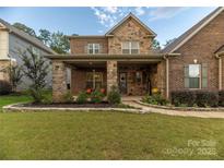 Charming two-story home with stone and brick facade, covered porch, and well-manicured lawn at 16827 Monocacy Blvd, Huntersville, NC 28078