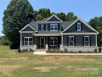 Charming two-story home featuring a landscaped yard, stone accents, and a welcoming front porch at 552 Fern Hill Rd # 21, Mooresville, NC 28117