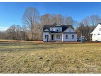 New construction home featuring a modern design, covered porch, and bright windows in a large lot at 552 Fern Hill Rd # 21, Mooresville, NC 28117