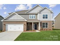 Two-story house with brick and siding, two car garage, and landscaped lawn at 219 E Warfield Dr, Mooresville, NC 28115