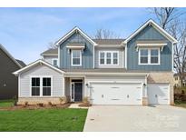 Two-story home boasts blue and gray siding, a two-car garage, and a well-maintained lawn at 227 E Warfield Dr, Mooresville, NC 28115