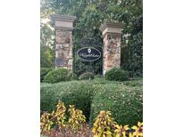 Stone pillar entrance to Highgate community, featuring lush landscaping and a decorative wrought iron gate at 2097 Kings Manor Dr # 53, Matthews, NC 28104