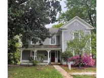 Charming two-story home with gray siding, blooming azaleas, and a welcoming front porch at 203 Kings Mountain St, Clover, SC 29710