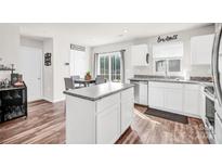 Bright kitchen with white cabinetry, granite countertops, stainless steel dishwasher, and an island at 1197 Tangle Ridge Se Dr, Concord, NC 28025