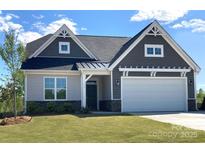 Gray-sided house with white garage door and landscaping at 166 Wylie Trl # 25, Statesville, NC 28677