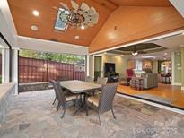 Covered patio with stone flooring, dining table, and views of the backyard at 316 W Kingston Ave, Charlotte, NC 28203