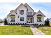 Charming two-story home with manicured lawn, brick walkway, and white exterior at 5704 Crescent Field Cir # 25, Huntersville, NC 28078