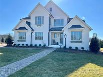 Charming two-story white brick home featuring a well-manicured lawn and inviting walkway at 5704 Crescent Field Cir # 25, Huntersville, NC 28078