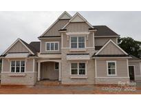 Stunning two-story home with stone accents, detailed windows, and a welcoming covered porch at 8111 Farm Crossing Ln # 2, Huntersville, NC 28078