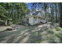 Two-story house with wrap-around porch, fire pit, and wooded lot at 17929 Pages Pond Ct, Davidson, NC 28036