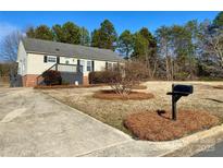 Ranch home with front yard landscaping and a paved driveway at 1520 Yellowstone Ct, Gastonia, NC 28054