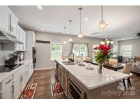 Modern kitchen featuring stainless steel appliances, pendant lighting, and a large island with quartz countertop at 3020 Pinehills Way, Mount Holly, NC 28120