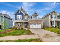 Charming brick two-story home featuring a two-car garage, well-maintained lawn and manicured landscaping at 10132 Whitaker Pointe Dr, Huntersville, NC 28078