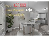 Bright dining area features modern table with stylish chairs and sleek gray plank flooring adjacent to the kitchen at 2223 Mancke Dr, Rock Hill, SC 29732