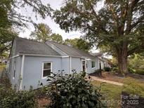 Charming single-story home with light blue siding, mature trees, and landscaped front yard at 131 Glendale Se Ave, Concord, NC 28025